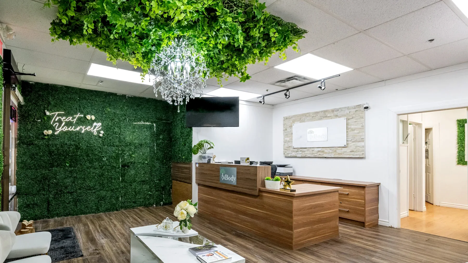 Real iBODY reception area with green wall and wood reception desk